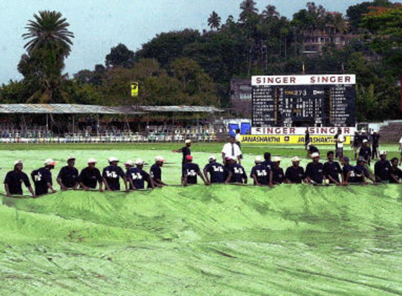 Ground staff cover the pitch during the second day of the second test match between Sri Lanka and West Indies, at Asgiriya Stadium in Kandy