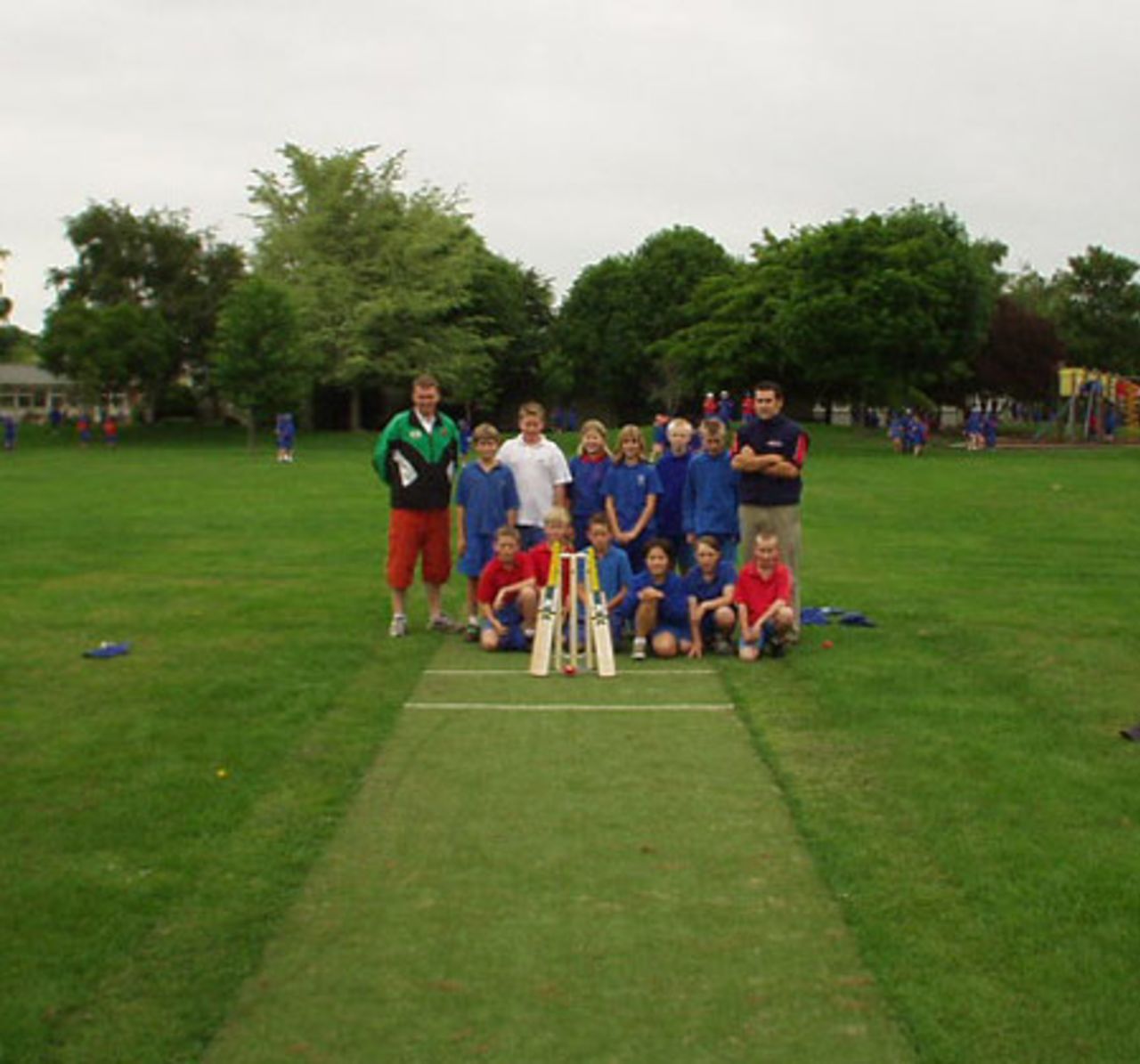 Mike Harvey (back left) and Doug McSweeney (back right) from the Canterbury Cricket Association at Hoon Hay Primary School with the school cricket team on a pitch laid through the CCA Artificial Plan.