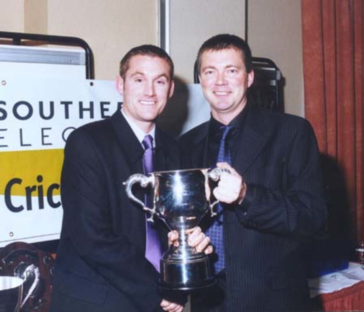 Neil Owen, Southern Electric Partnership Accounts Manager, presents the ECB Premier Division I trophy to BAT Sports captain David Banks.