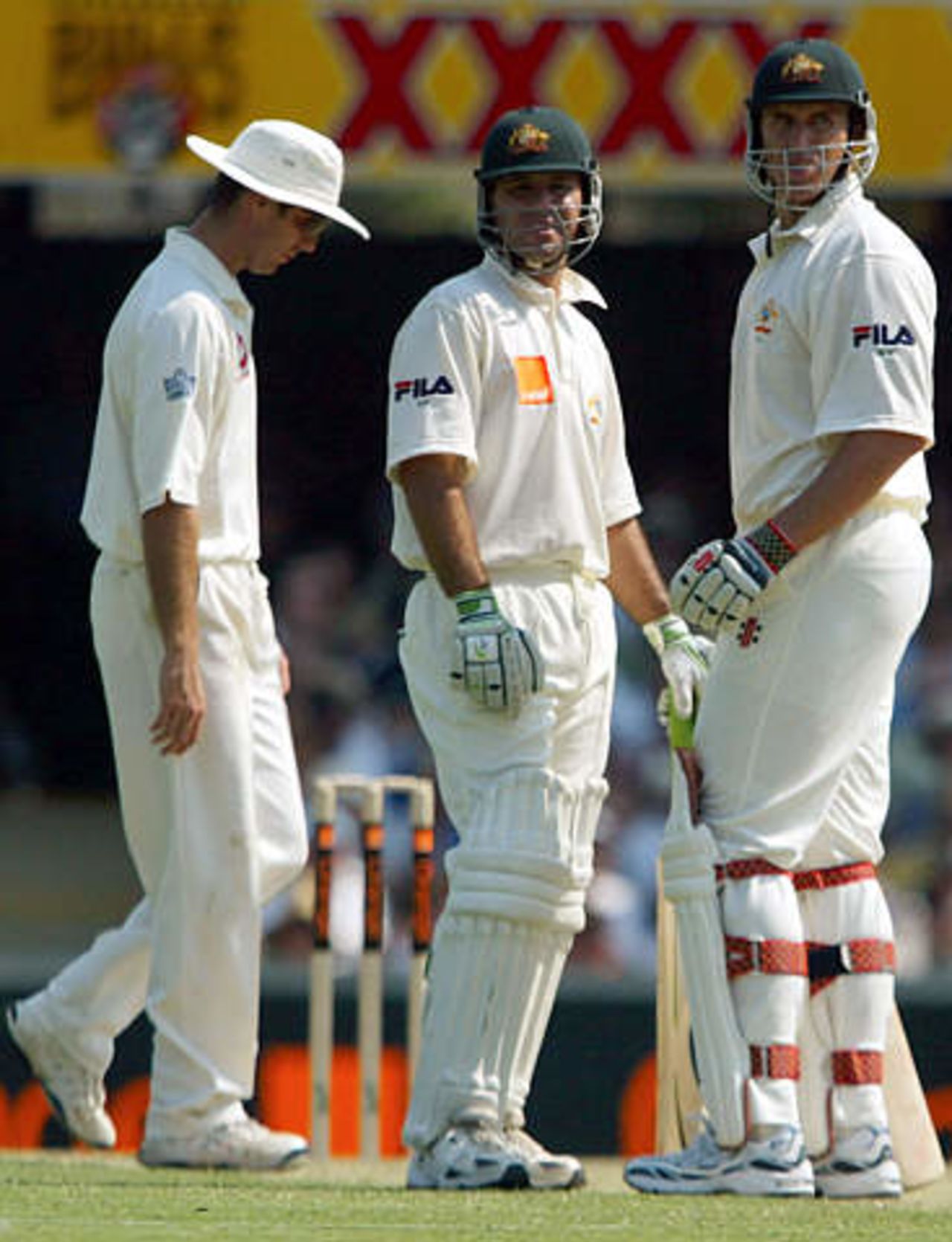 Australia's Matthew Hayden (R) and Ricky Ponting (C) talk as England's Michael Vaughan walks behind during the first day's play in the first Ashes test match at the Gabba in Brisbane November 7, 2002.