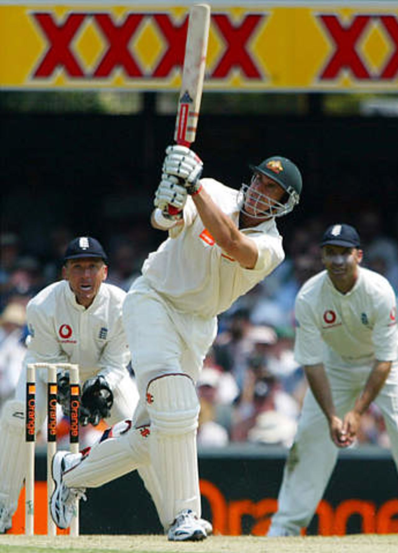 Australia's Matthew Hayden (C) hits a four during his century innings as England's captain Nasser Hussain (R) and wicket-keeper Alec Stewart look on during the first day's play in the first Ashes test match at the Gabba in Brisbane November 7, 2002.