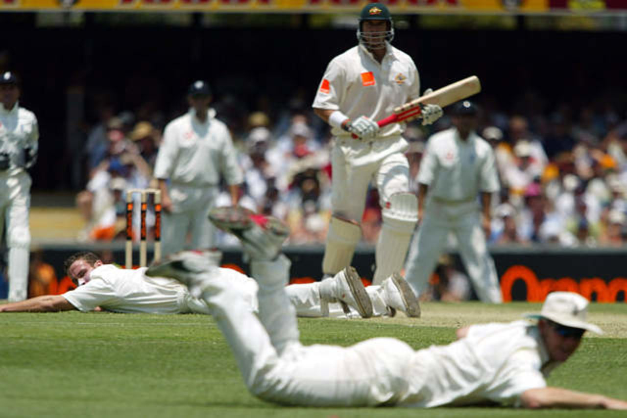 Australia's Matthew Hayden (C) watches as England's Simon Jones (L) and Ashley Giles (R) dive to try and stop a four during the first day's play in the first Ashes test match against England at the Gabba in Brisbane November 7, 2002