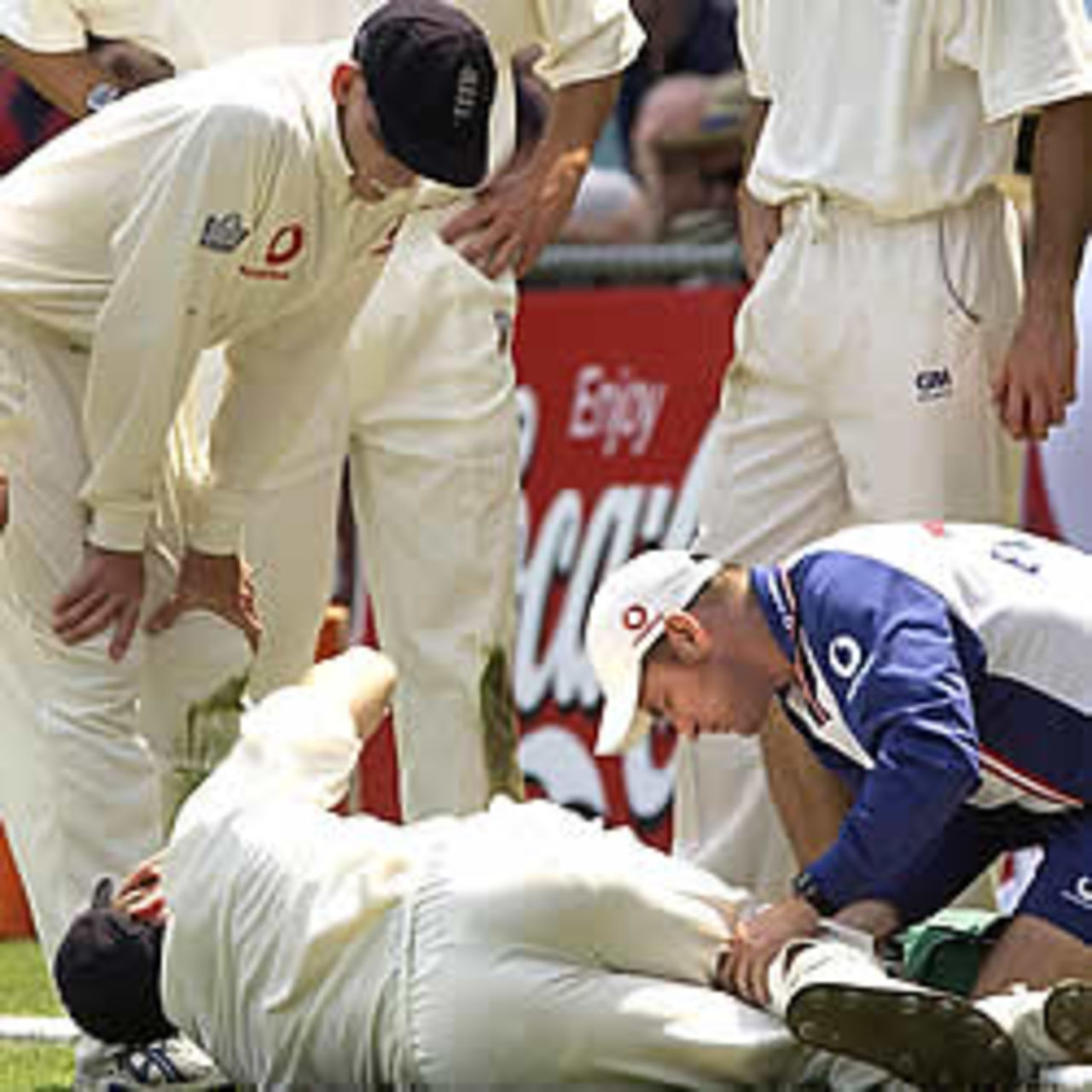BRISBANE - NOVEMBER 7: England team physiotherapist, Kirk Russel attends to the injured leg of Simon Jones during day one of the first Ashes Test between Australia and England at the Gabba, Brisbane, Australia on November 7, 2002.