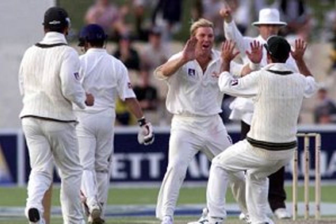11 Dec 1999: Shane Warne of Australia celebrates the wicket of Rahul Dravid of India with team mate Ricky Ponting with umpire Daryl Harper raising his finger in the background, on two of the first test between Australia and India, at the Adelaide Oval, Adelaide, Australia.