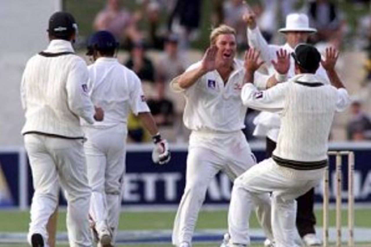11 Dec 1999: Shane Warne of Australia celebrates the wicket of Rahul Dravid of India with team mate Ricky Ponting with umpire Daryl Harper raising his finger in the background, on two of the first test between Australia and India, at the Adelaide Oval, Adelaide, Australia.