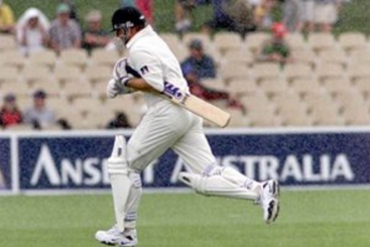 11 Dec 1999: Shane Warne of Australia runs for cover during a rain delay, on two of the first test between Australia and India, at the Adelaide Oval, Adelaide, Australia.