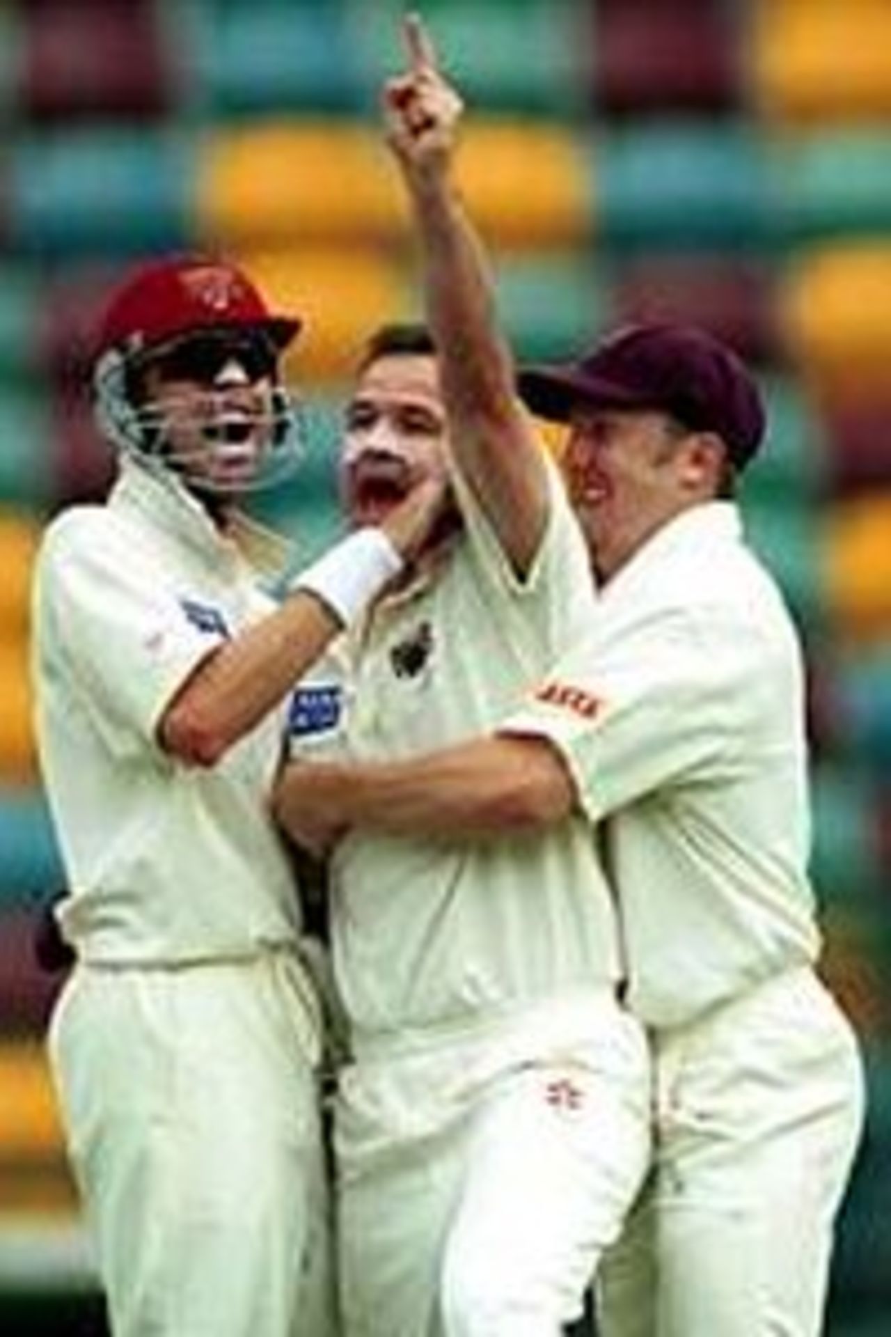 17 Dec 1999: Adam Dale of Queensland celebrates  with team mates after taking the wicket of Jason Arnberger of Victoria  during the Pura Milk Cup match at the Gabba Cricket Ground in Brisbane,  Australia.