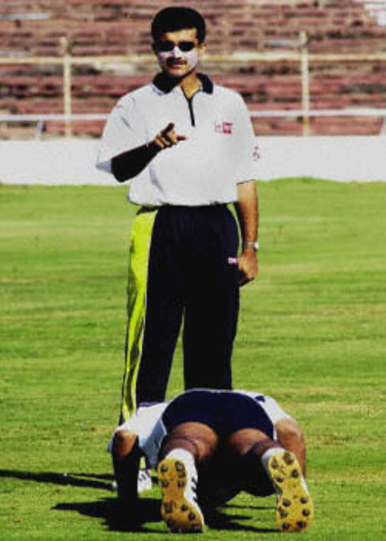 Sourav Ganguly, Indian cricket captain keeps count on push-ups being done by successful bowler Zaheer Khan at a net session 04 December 2000, at the Motera stadium in Ahmedabad where they take on Zimbabwe in the second one-day international cricket match.