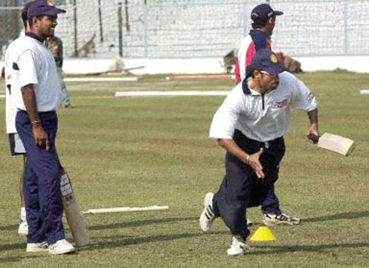 India's star batsman Sachin Tandulkar (R) warms up as spin bowler Sunil Joshi (L) looks on during practice in Kanpur 10 December 2000. India, leading 2-1 in the five-match series, will play its fourth one-day cricket match against Zimbabwe 11 December.