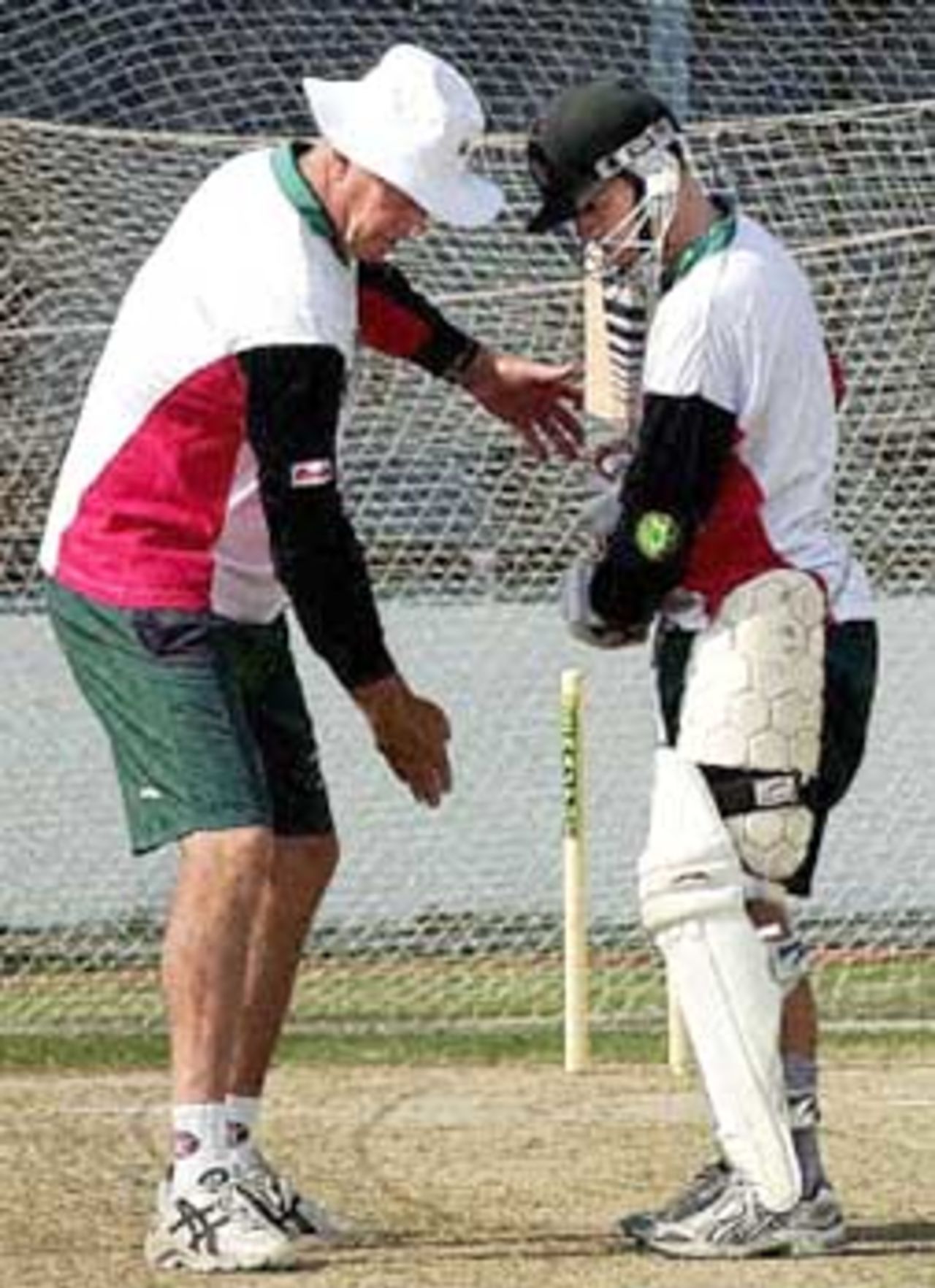 Zimbabwe's coach, Carl Rackemann (L), discusses batting technique with Zimbabwe batsman Stuart Carlisle at net practice in Kanpur 10 December 2000 on the eve of the fourth one-day cricket match against India. India leads the five-match series 2-1.
