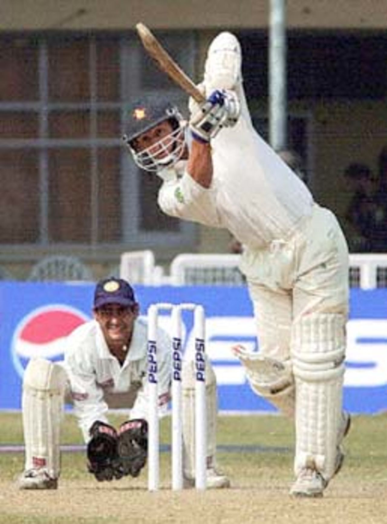 Zimbabwe batsman Guy Whittall hits a delivery from Indian pace bowler Venkatesh Prasad (not in picture) as Indian wicketkpeer Vijay Dahiya (L) looks on during the fourth one-day international match between India and Zimbabwe at Green Park ground in Kanpur 11 December 2000. Zimbabwe were shot out 165 for 45.5 overs in the crucial fourth one-dayer.
