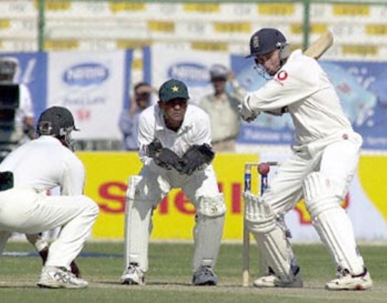 England opener Michael Atherton (R) plays a defensive push off a Pakistani spinner as wicketkeeper Moin Khan (C) and fielder Yousuf Youhanna (L) look on, during the third-day of the third and final Test at the National stadium in Karachi, 09 December 2000. Atherton was 76 not out as England reached 145-1 at lunch in reply to Pakistan's 405 in their first innings.