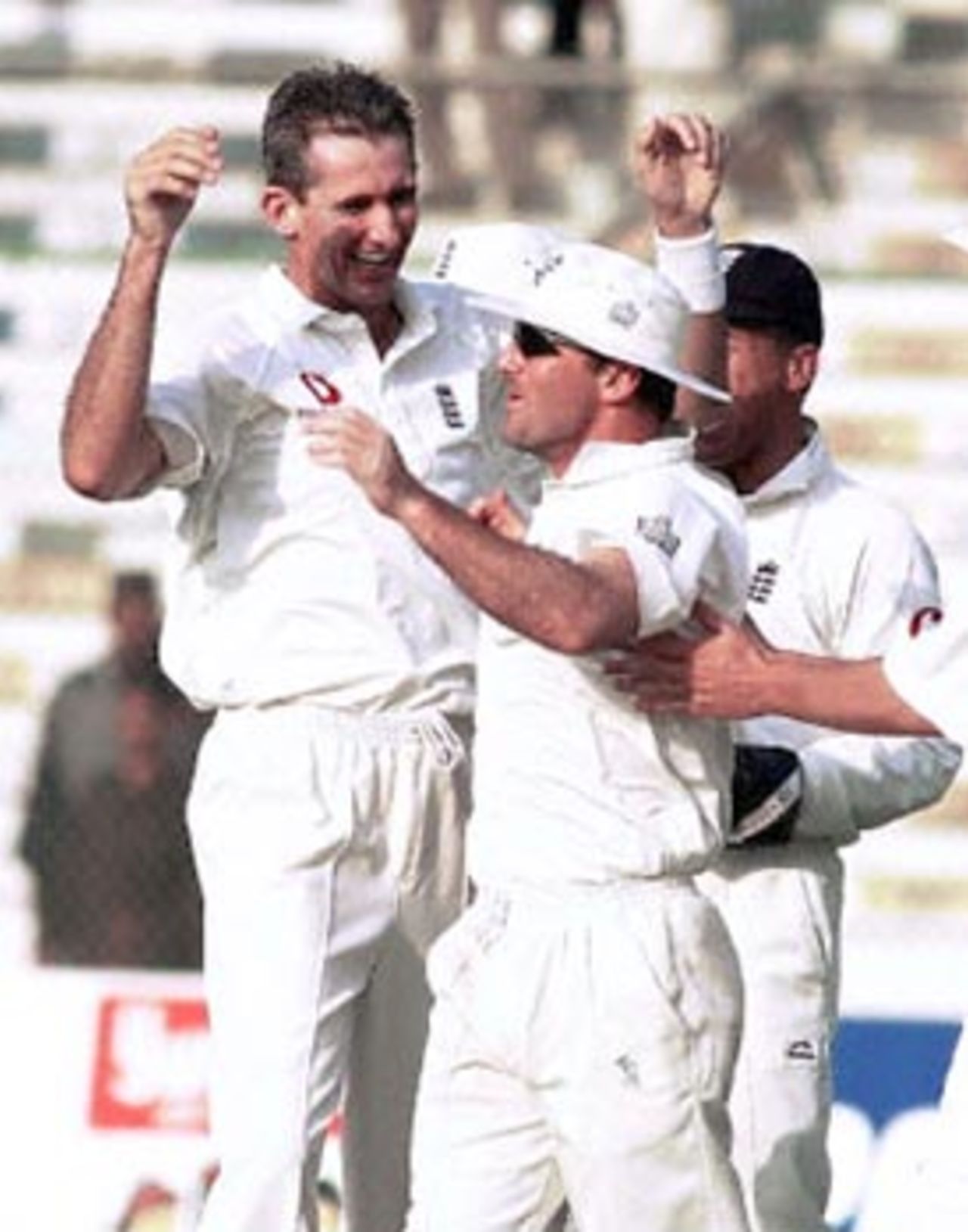 England's fast bowler Andrew Caddick (L) shares celebrations with teammate Graham Thorpe (R) following the fall of Pakistan's Saeed Anwar's wicket on the fourth day of the third Test at the National Stadium in Karachi, 10 December 2000. Pakistan's fast bowler Waqar Younis took four wickets as England were bowled out for 388 at tea in the first innings.