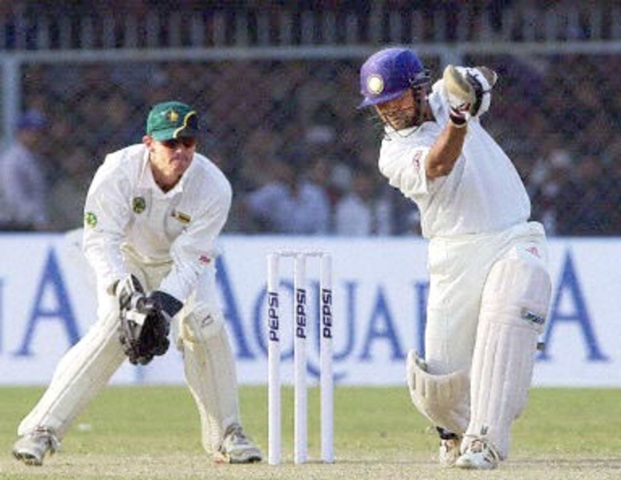Indian star batsman Sachin Tendulkar (R) hits a delivery off Zimbabwe bowler Brian Murphy (not in picture) as Zimbabwean wicketkeeper Andy Flower (L) looks on during the fourth one-day cricket match in Kanpur, 11 December 2000. India won the match by nine wickets to take the series 3-1.