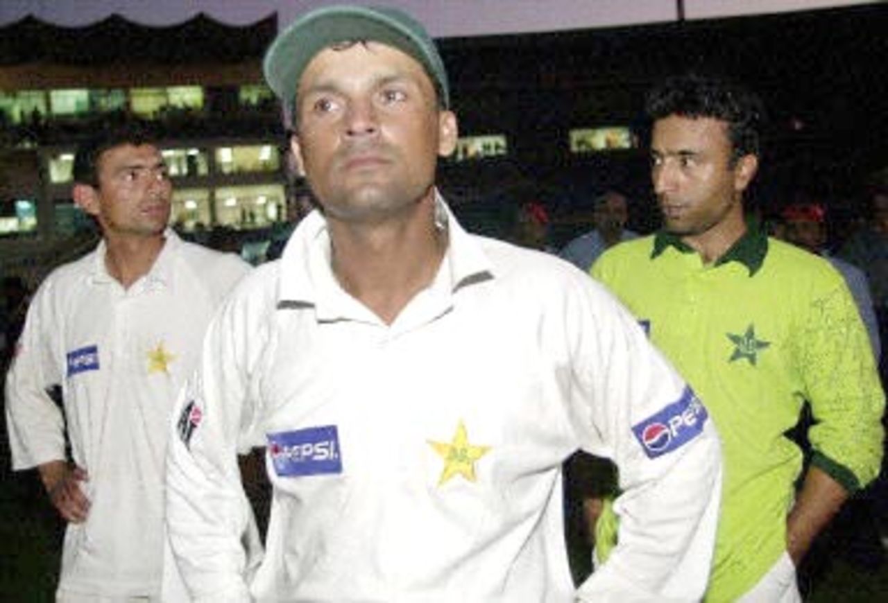 Dejeceted Pakistani cricket captain Moin Khan (C), pose with team members Saqlain Mushtaq (L) and Saeed Anwar during the presentaion ceremony at the National stadium in Karachi, after their loss against England by six wicket in the third cricket Test match, 11 December 2000. England clinched a historic series victory, snatching a stunning win with just minutes to spare in the third and final Test. England's six-wicket triumph makes them the first English side to win a Test in Pakistan since 1962 and end the hosts' unbeaten record in 34 encounters.