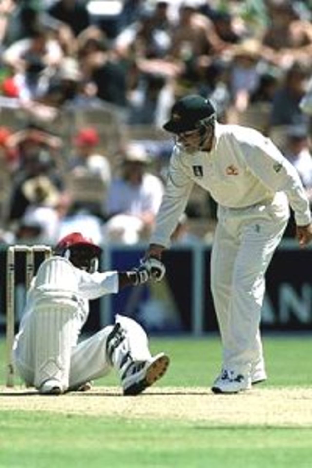 15 Dec 2000: Sherwin Campbell of West Indies is helped to his feet by short leg Justin Langer of Australia after being felled by a bouncer from Glenn McGrath of Australia during the first days play of the Third Test match at the Adelaide Oval in Adelaide, Australia.