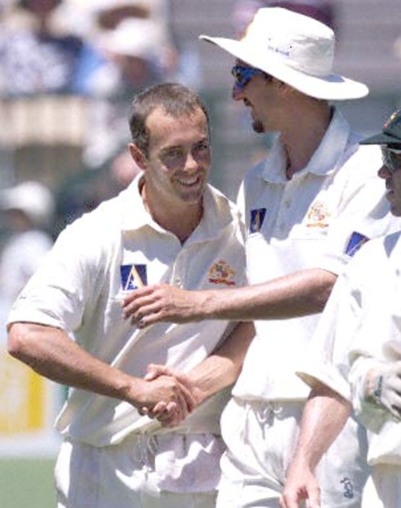 Australian spin bowler Colin Miller (L) is congratulated by teammate and fast bowler Jason Gillespie (R) as the team leave the field on day two of the third test match against the West Inidies at the Adelaide oval 16 December 2000. The West Indies were dismissed in their first innings for 391 runs, with Miller taking five wickets for 81, and Gillespie five wickets for 89.