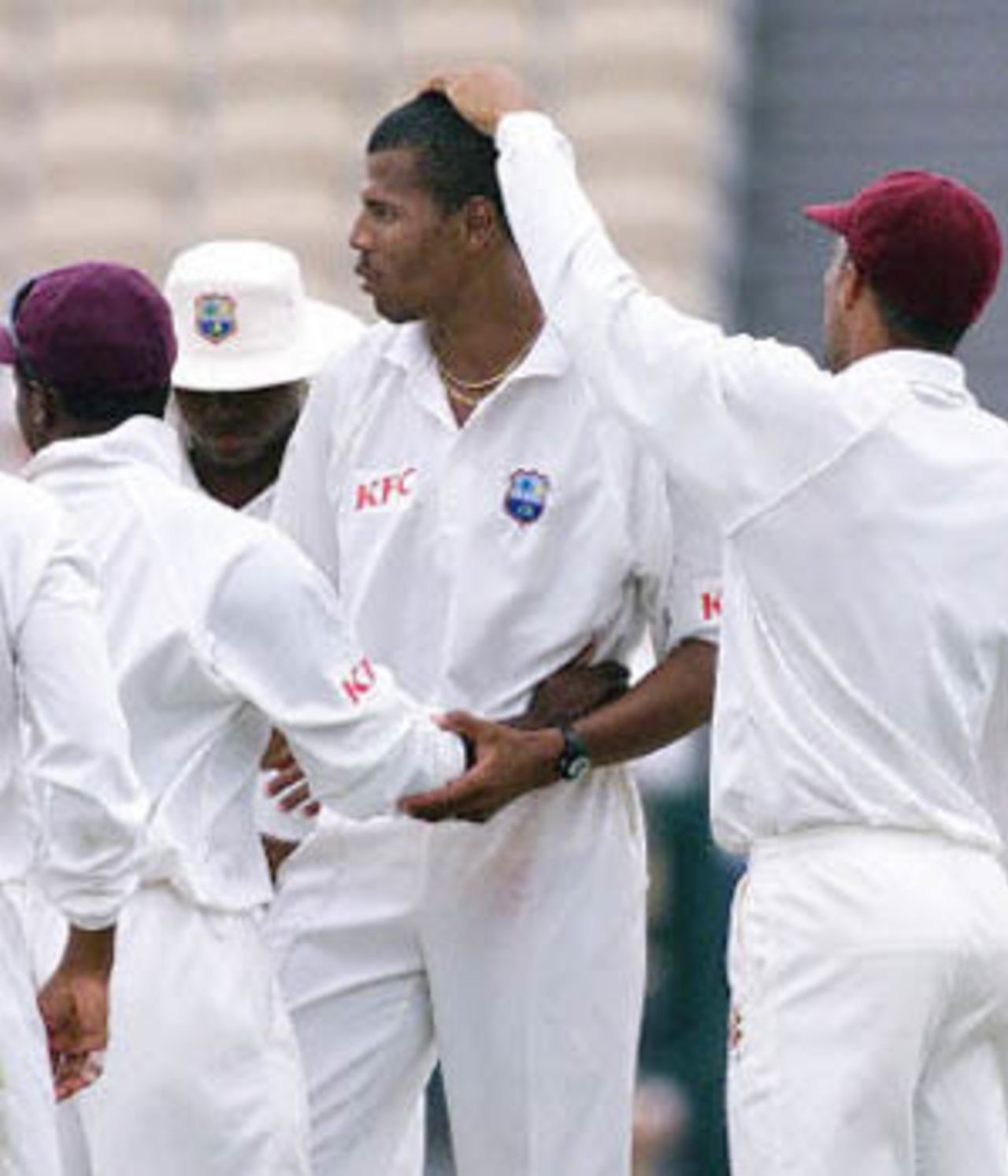 West Indies fast bowler Mervyn Dillon (C) receives a pat on the head from captain Jimmy Adams (R) after taking the wicket of Australian batsman Mark Waugh for 63 runs, on day three of the third Test match at the Adelaide Oval, 17 December 2000. Australia, currently on six for 379, is chasing the West Indies first innings score of 391.