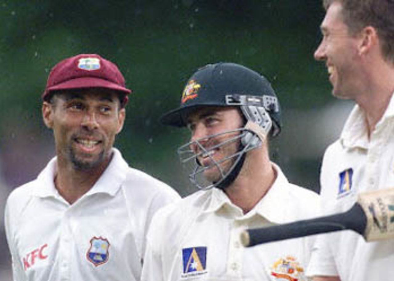 West Indies captain Jimmy Adams (L) chats with Australian batsmen Damien Martyn (C) and Glenn McGrath (R) as the players walk off after play was stopped due to rain, on day three of the third Test match at the Adelaide Oval, 17 December 2000. At the stoppage Australia were nine for 403, 12 runs ahead of the West Indies first innings total of 391, with Martyn not out on 46 and McGrath not out on one.