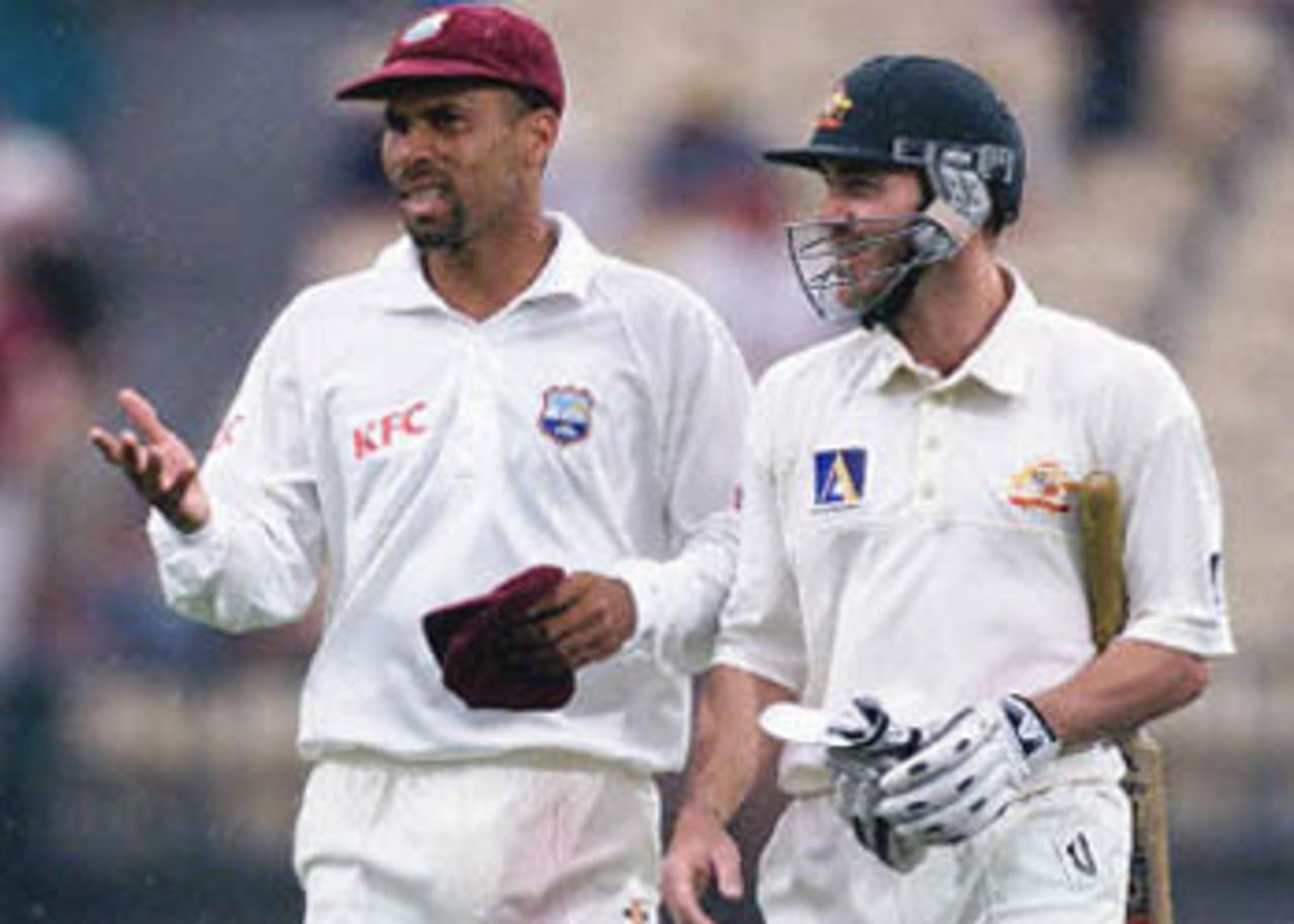 West Indies captain Jimmy Adams (L) talks with Australian batsmen Damien Martyn (R) as the players walk off after play was stopped due to rain on day three of the third Test match at the Adelaide Oval, 17 December 2000. At stoppage Australia were nine for 403, 12 runs ahead of the West Indies first innings total of 391, with Martyn not out on 46.