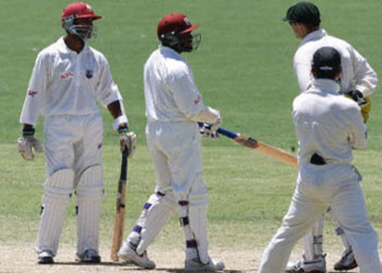 West Indies batsmen Brian Lara (C) and Daren Ganga (L) have a midpitch confrontation with Australian captain Adam Gilchrist (2nd R), watched by Justin Langer (R) on day four of the third Test match at the Adelaide Oval, 18 December 2000. The confrontation was a result of Ganga being given not out off the bowling of Colin Miller and comes after a clash 17 December between Miller and West Indies 12th man Ramnaresh Sarwan. Australia survived some anxious moments to ease themselves into a winning position against the West Indies, as the home team went to stumps with 98 for four, needing just another 32 runs, to be well poised to extend to 13 their world record sequence of Test victories.
