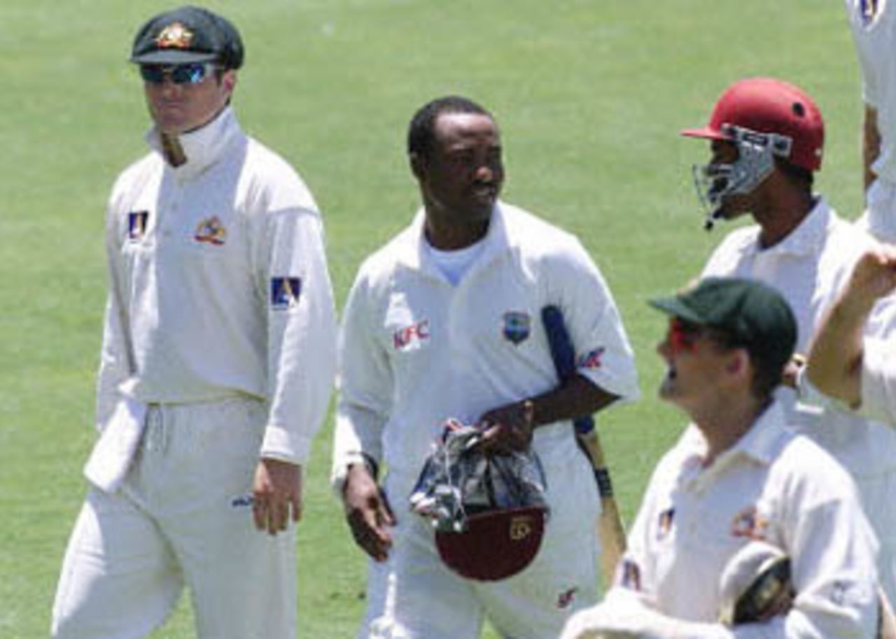 West Indies batsmen Brian Lara (C) and Daren Ganga (top R) leave the field alongside Australians Colin Miller (L) and Adam Gilchrist (bottom R) at lunch on day four of the third Test match at the Adelaide Oval, 18 December 2000. The match became heated after a confrontation between Lara and Gilchrist during play and came after a clash 17 December between Miller and West Indies 12th man Ramnaresh Sarwan. Australia survived some anxious moments to ease themselves into a winning position against the West Indies, as the home team went to stumps with 98 for four, needing just another 32 runs, to be well poised to extend to 13 their world record sequence of Test victories.