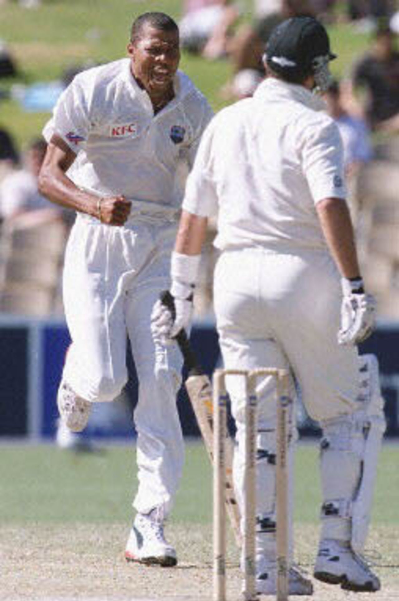 West Indies fast bowler Mervyn Dillon (L) charges down the pitch shouting, after taking the prize wicket of Australian batsman Mark Waugh (R) for five runs on day four of the third Test match at the Adelaide Oval, 18 December 2000. Australia, who have six wickets in hand, only need to score 32 runs 19 December to win the match and extent their world record match streak to 13.