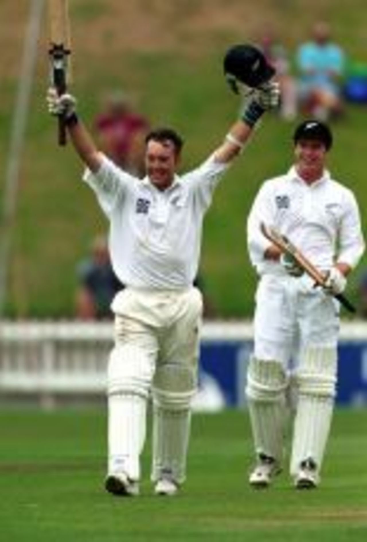 Craig McMillan raises his bat in celebration of a Test century against Zimbabwe at Wellington