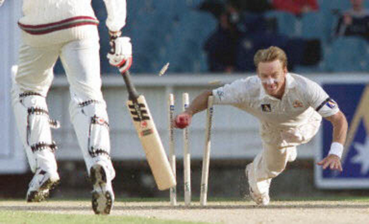 Australian fast bowler Andrew Bichel runs out West Indian batsman Courtney Walsh (L) as the West Indies just manage to avoid the follow on on the second day of the fourth Test Match at the MCG in Melbourne, 27 December 2000. The West Indies scored 165 runs in their first innings in reply to Australia's total of 364 runs with Australia to start their second innings tomorrow December 28.