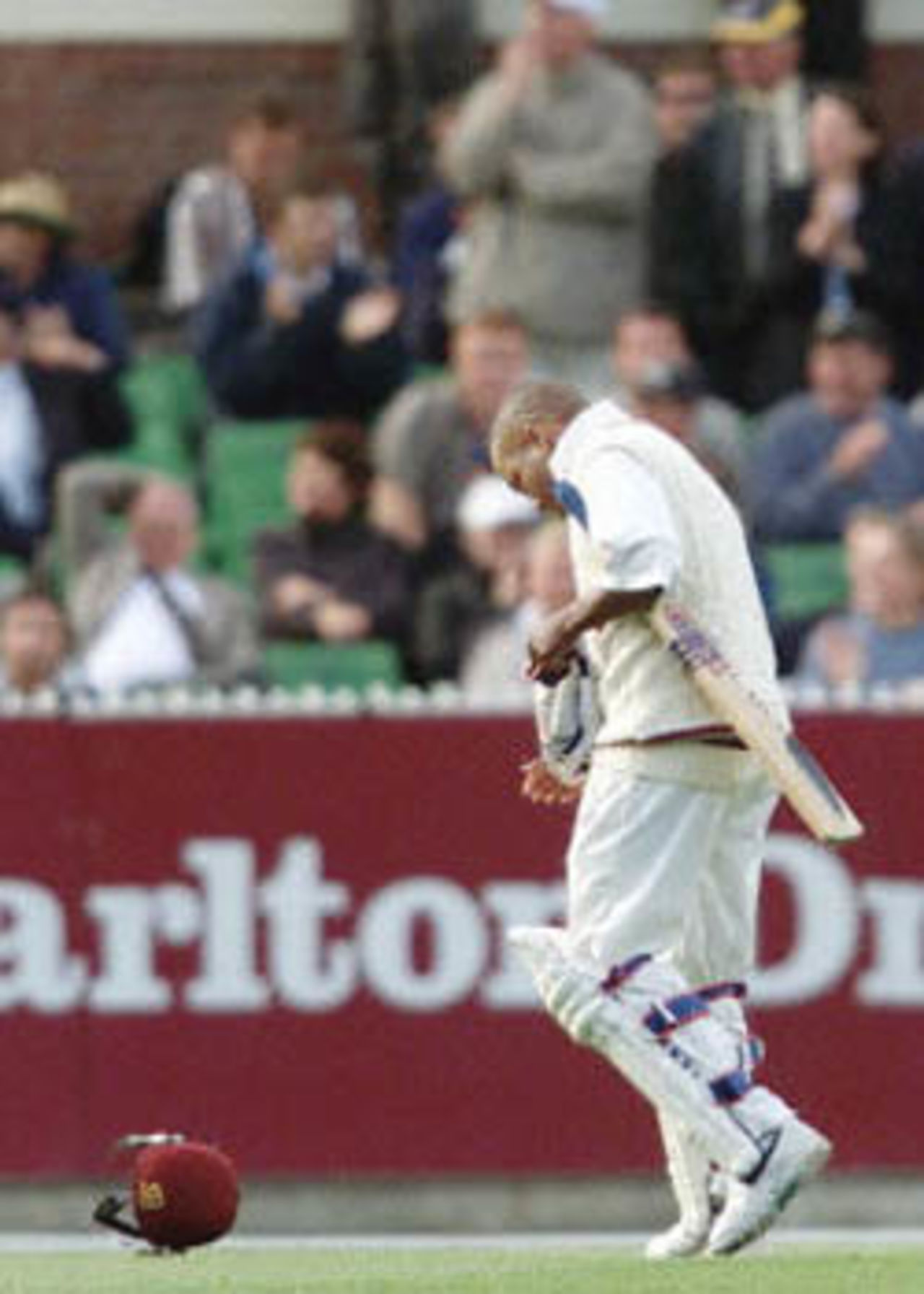 Dejected West Indian star batsman Brian Lara drops his helmet as he leaves the field after being clean bowled by Australian paceman Jason Gillespie on the third day of the fourth Test Match at the MCG in Melbourne, 28 December 2000. Australia declared their second innings close at 262-5 and at stumps the West Indies are again in deep trouble at 10-3 chasing 462 to win.