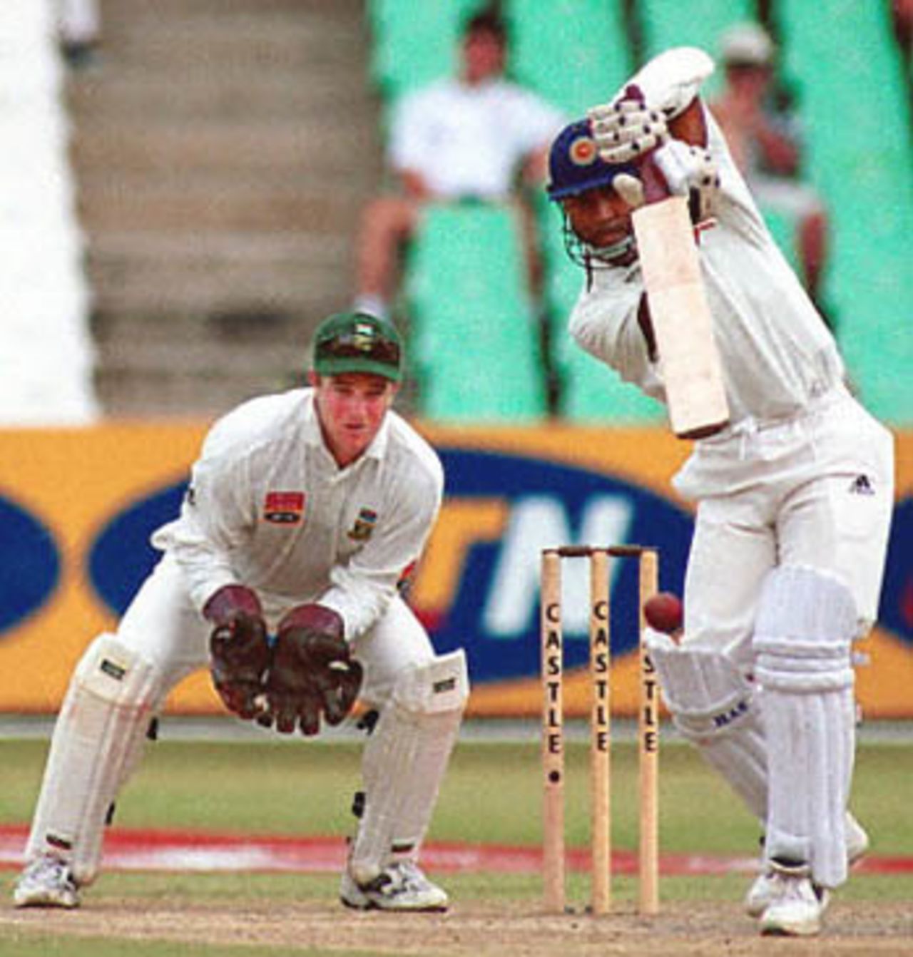 Sri Lankan batsman Romesh Kaluwitharana plays a cover drive at Durban's Kingsmead cricket grounds, 28 December 2000, during the third day of the first Test match between South Africa and Sri Lanka. Looking on is South African wicket-keeper Mark Boucher.
