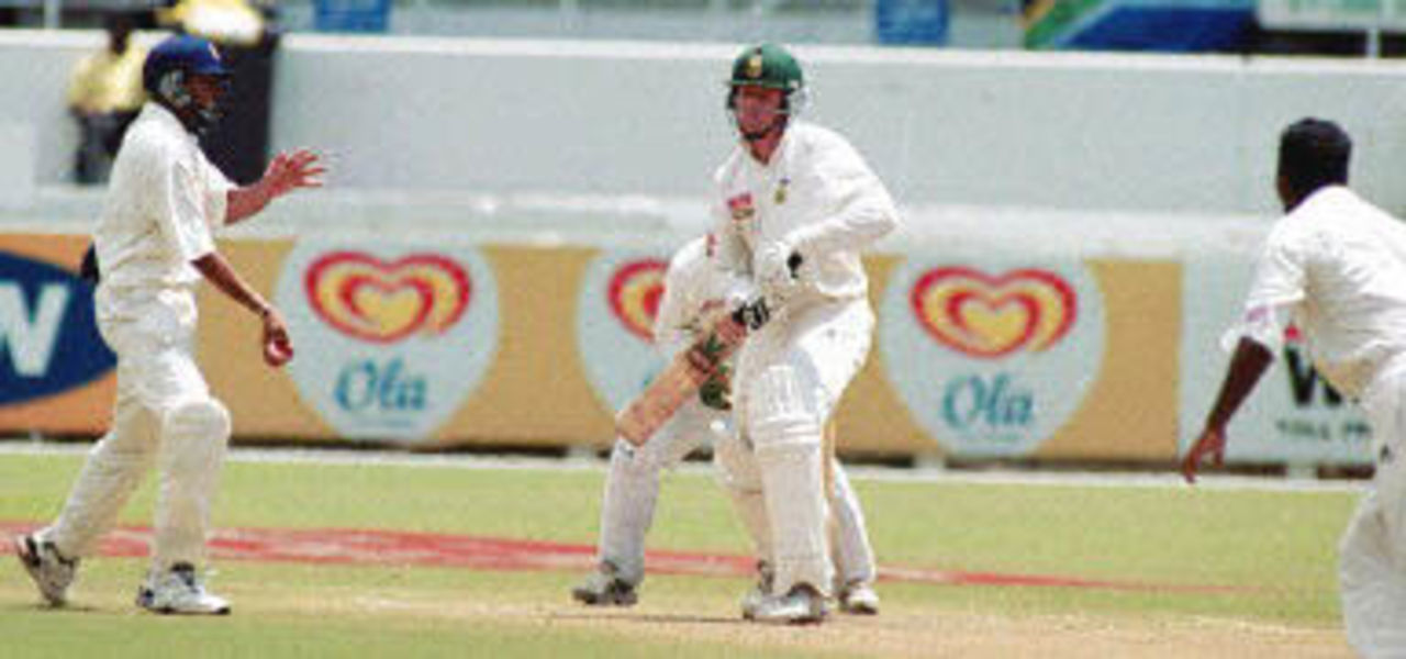 Sri Lankan off spinner Muttiah Muralitharan (L) bags the 300th wicket of South African captain Shaun Pollock (C) as his caught at silly point by Tillekaratne Dilshan at Durban's Kingsmead cricket stadium, 30 December 2000 on the fifth and final day of the first test match between South Africa and Sri Lanka.
