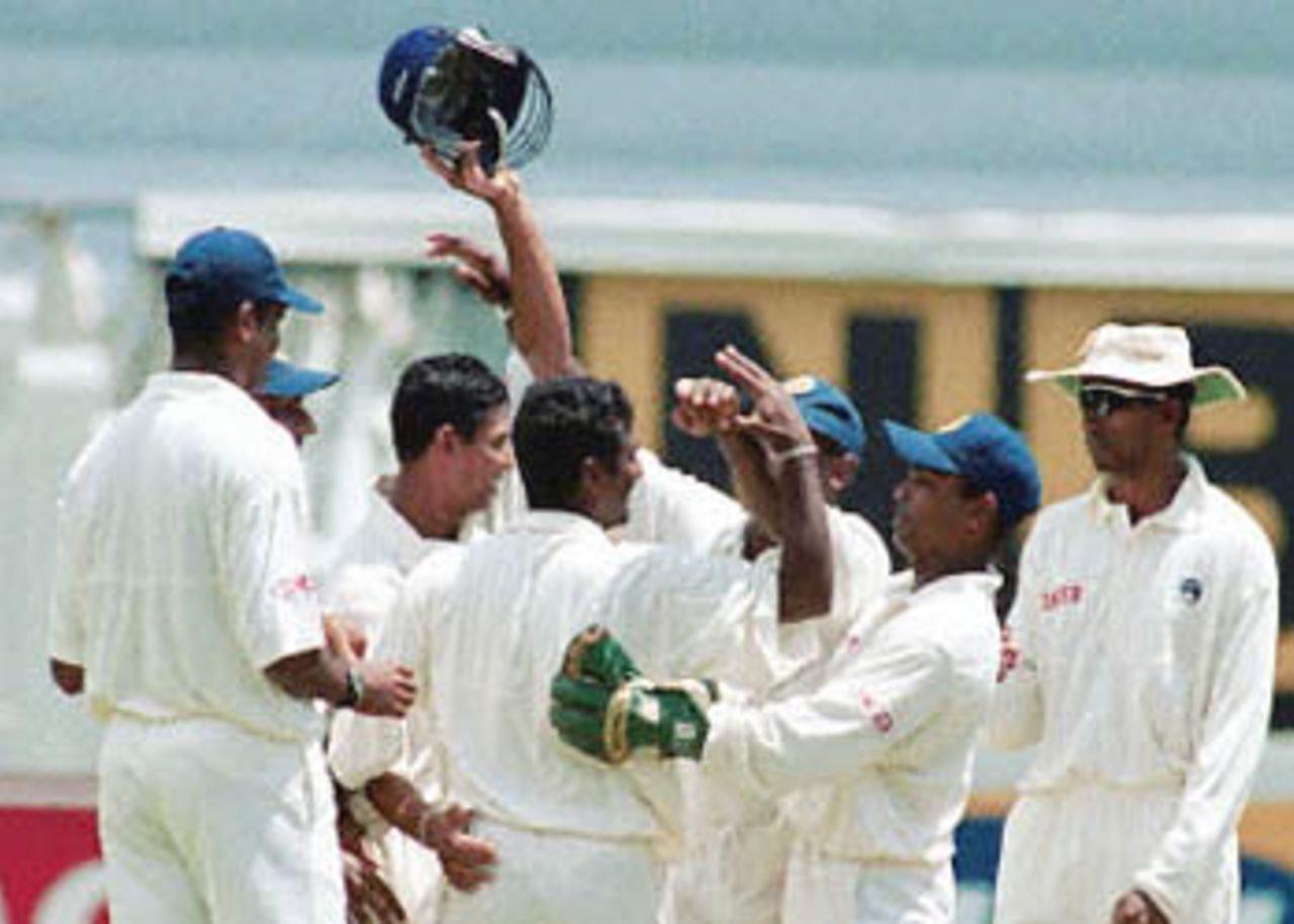 Sri Lankan off spinner Muttiah Muralitharan bags the 300th wicket in Test match cricket and is congratulated by his fellow teammates at Durban's Kingsmead cricket stadium, 30 December 2000 on the fifth and final day of the first test match between South Africa and Sri Lanka.