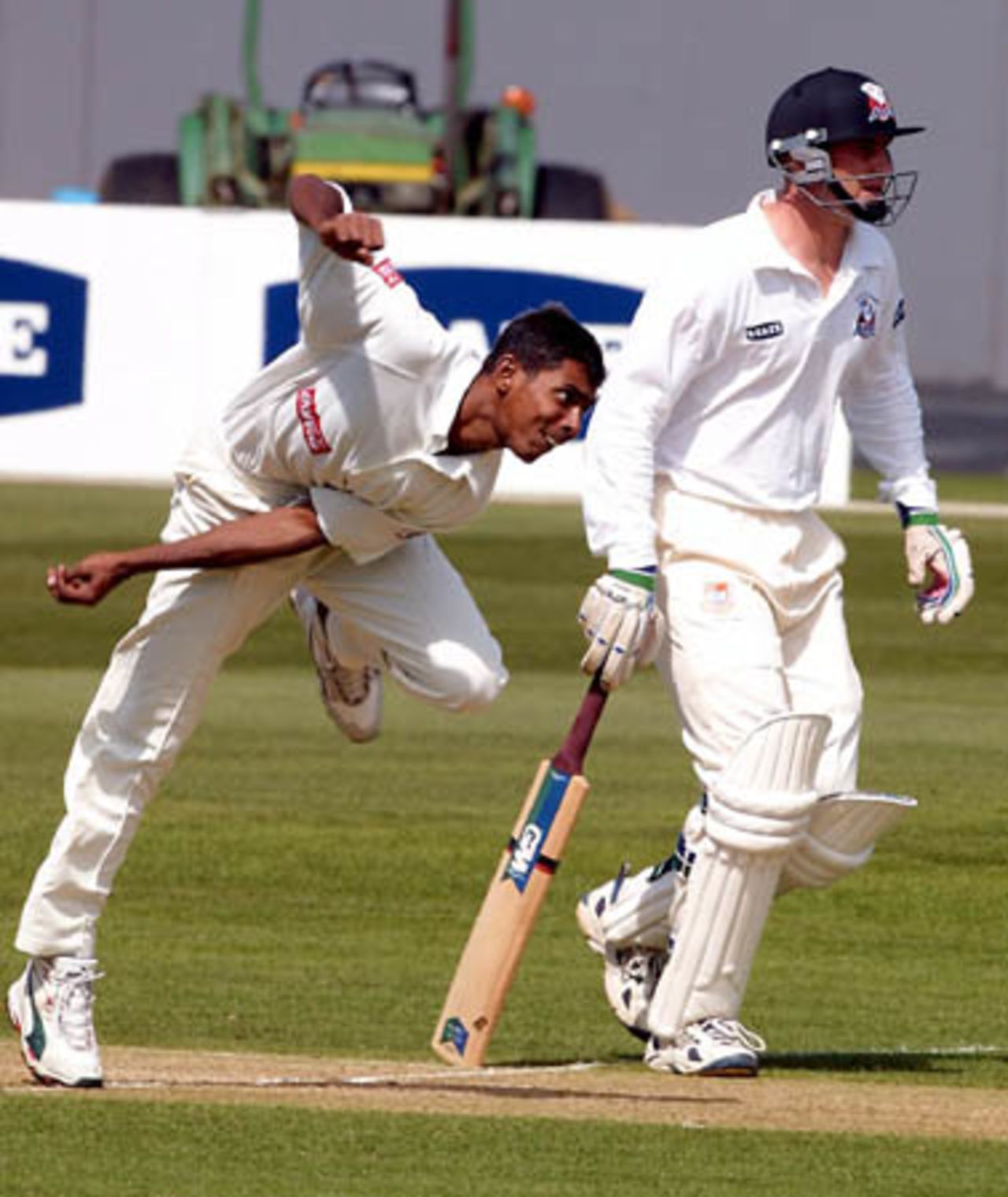 Bangladeshi bowler Manjural Islam delivers a ball during his spell of 4-105 from 38 overs. Auckland batsman Matt Horne looks on from the non-striker's end. Tour match: Auckland v Bangladeshis at Eden Park Outer Oval, Auckland, 12-15 Dec 2001 (12 December 2001).
