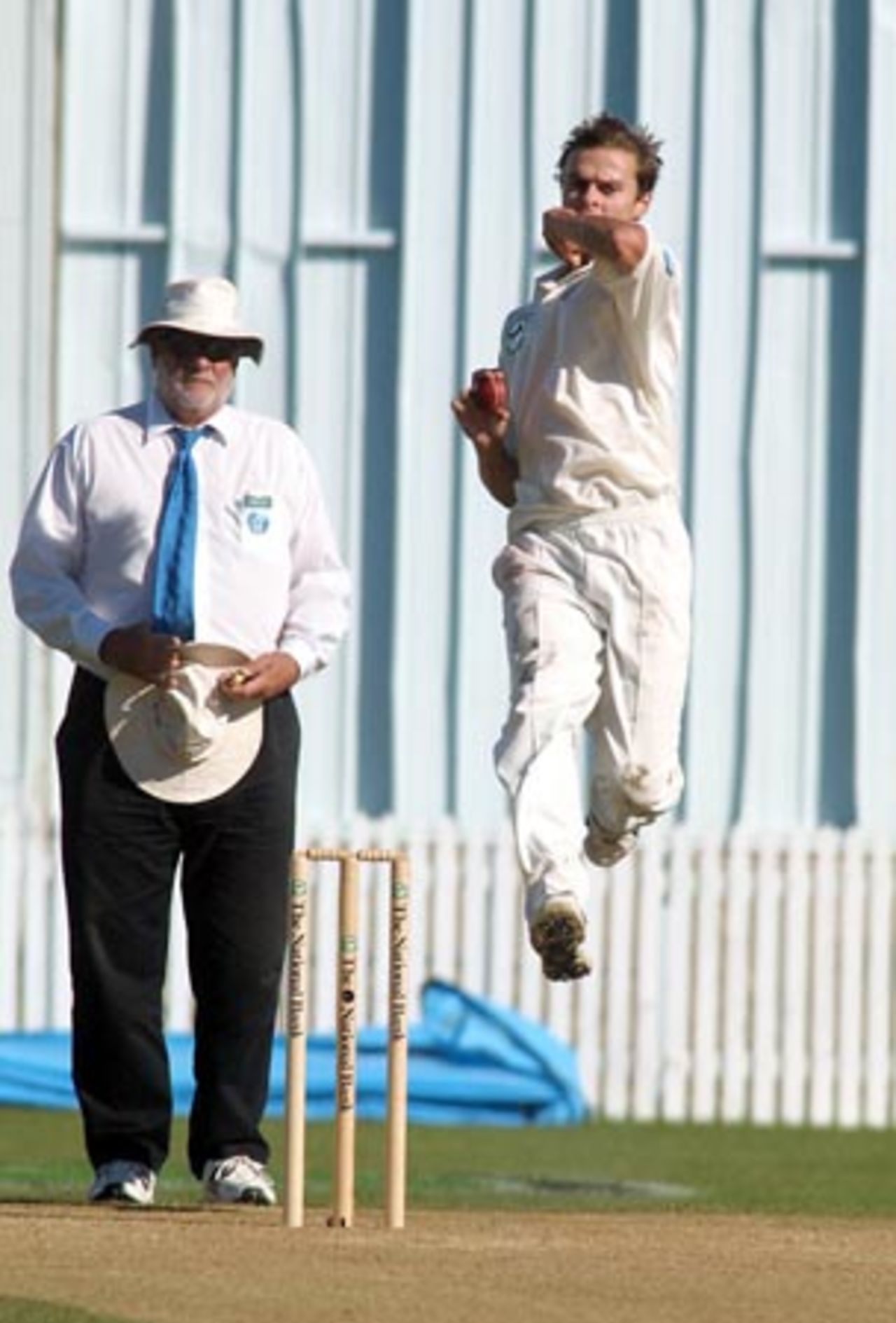New Zealand bowler Chris Martin leaps as he is about to deliver a ball during his second innings spell of 1-6 from four overs. Umpire David Orchard from South Africa looks on. 1st Test: New Zealand v Bangladesh at WestpacTrust Park, Hamilton, 18-22 Dec 2001 (21 December 2001).
