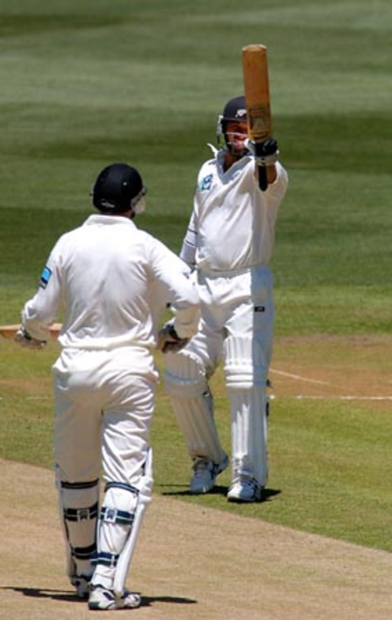 New Zealand batsman Mark Richardson raises his bat upon reaching his 50. Richardson went on to score 83 in his first innings. Batting partner Matt Horne looks on. 2nd Test: New Zealand v Bangladesh at Basin Reserve, Wellington, 26-30 Dec 2001 (29 December 2001).