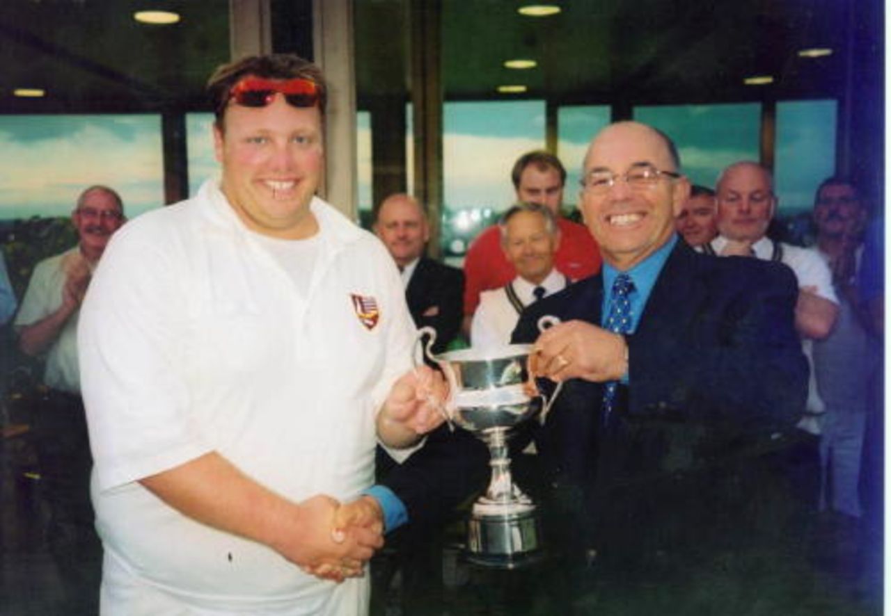 Russell Rowe receives the SEC Trophy from SPCL Chairman Alan Bundy.