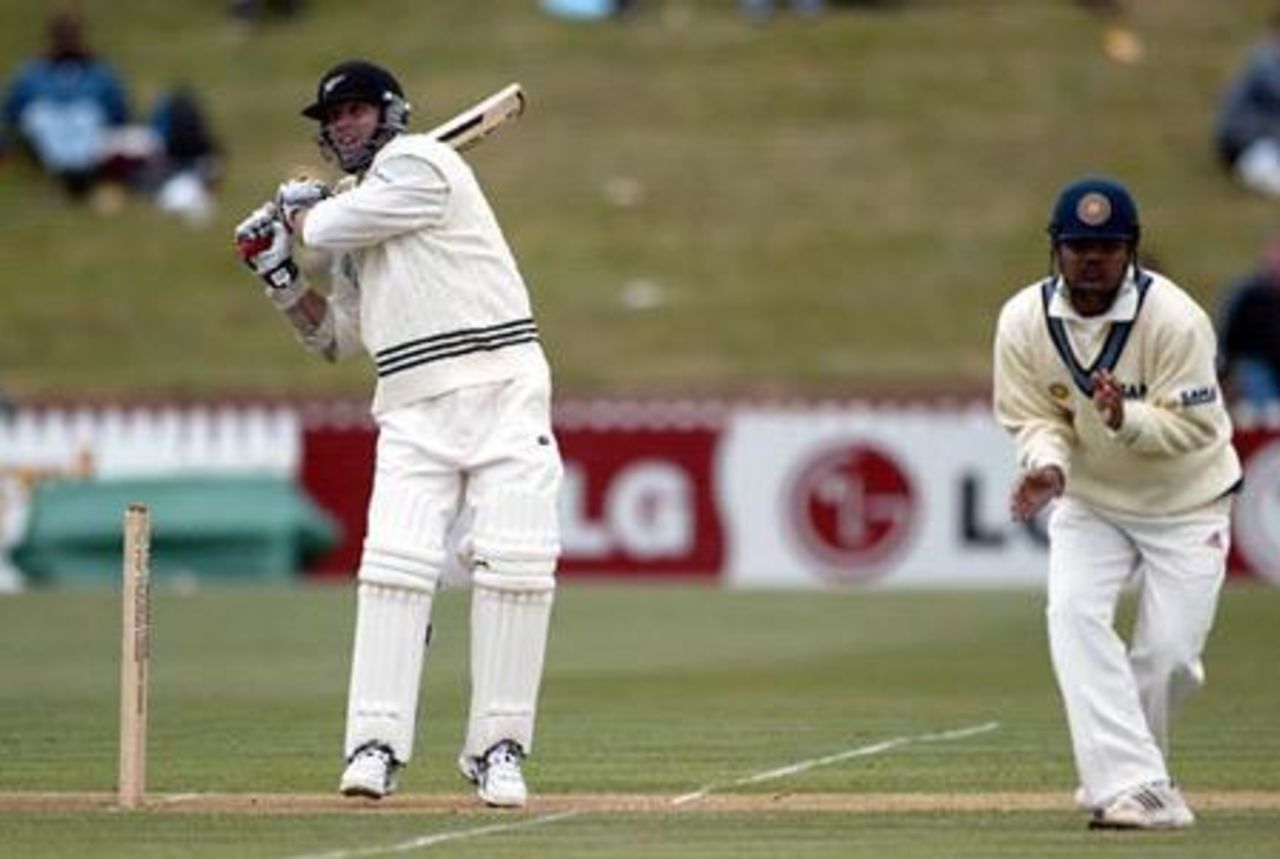 New Zealand batsman Mark Richardson hooks a short delivery to the boundary during his first innings of 27 not out on the first day as Indian fielder Virender Sehwag shies away at short leg. 1st Test: New Zealand v India at Basin Reserve, Wellington, 12-16 December 2002 (12 December 2002).