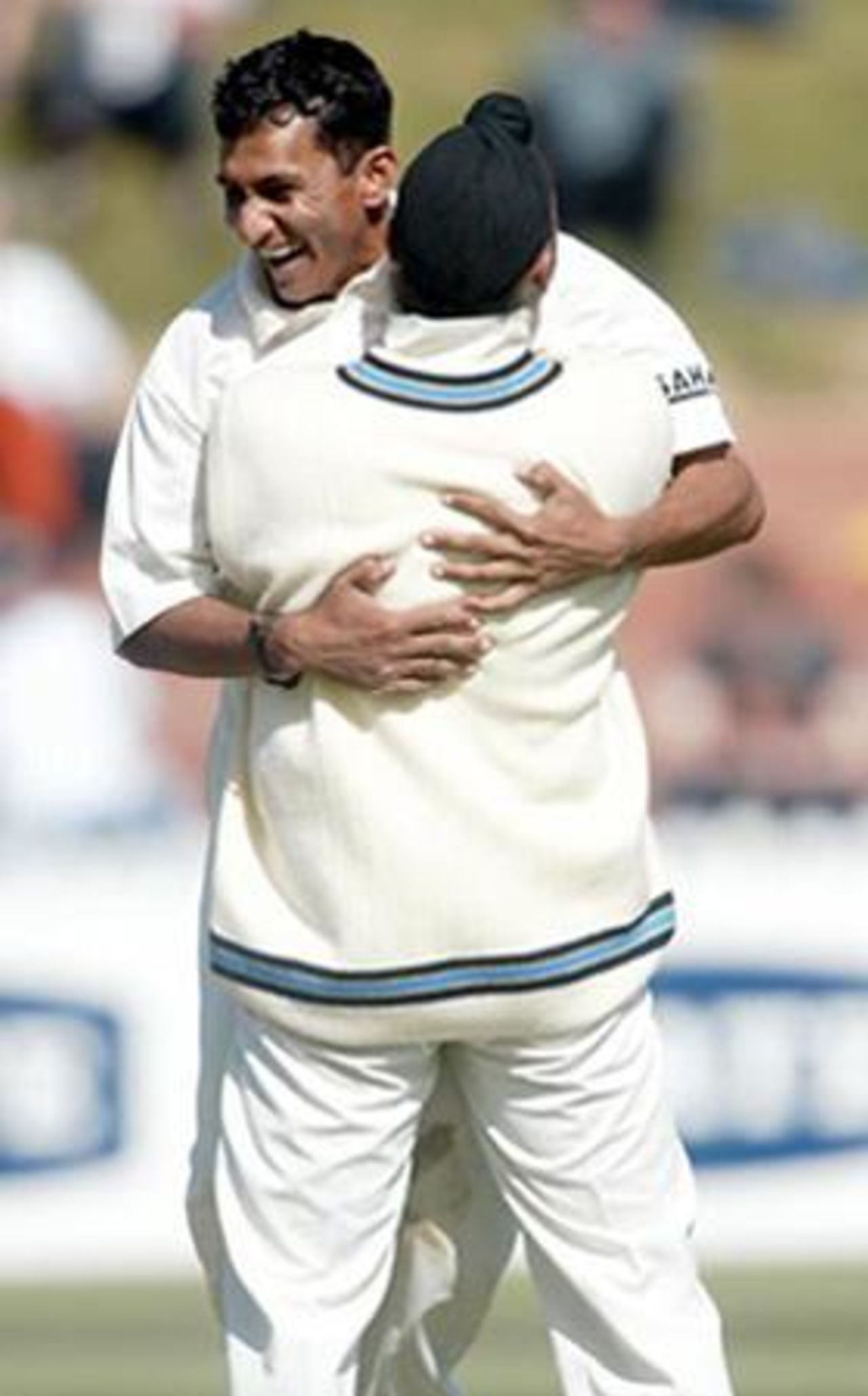 Indian bowler Sanjay Bangar (left) hugs team-mate Harbhajan Singh to celebrate the dismissal of New Zealand batsman Craig McMillan, lbw to Bangar in his first innings for nine. 1st Test: New Zealand v India at Basin Reserve, Wellington, 12-16 December 2002 (13 December 2002).