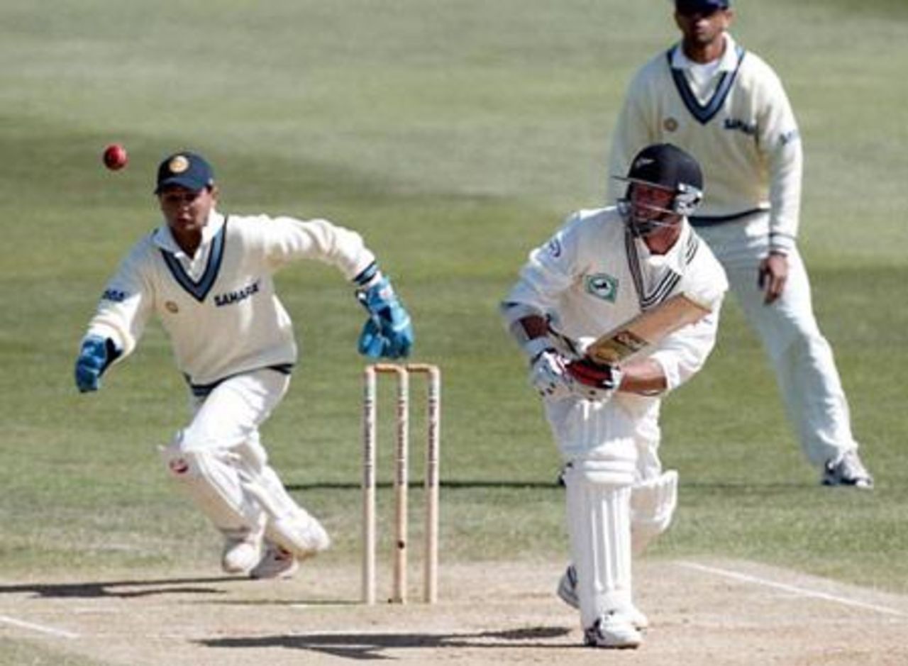 Indian wicket-keeper Parthiv Patel chases the ball after New Zealand batsman Mark Richardson plays a delivery from bowler Harbhajan Singh to the leg side during his second innings of 14 not out. Slip fielder Rahul Dravid looks on in the background. 1st Test: New Zealand v India at Basin Reserve, Wellington, 12-16 December 2002 (14 December 2002).