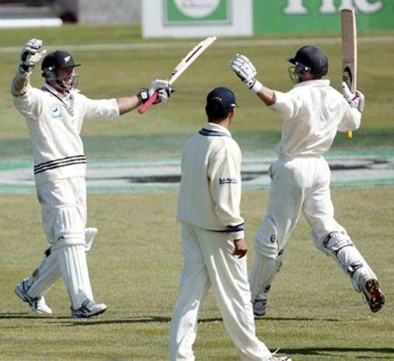 New Zealand batsmen Mark Richardson (left) and Lou Vincent celebrate New Zealand winning the match, beating India by 10 wickets. Indian captain Sourav Ganguly looks on. 1st Test: New Zealand v India at Basin Reserve, Wellington, 12-16 December 2002 (14 December 2002).
