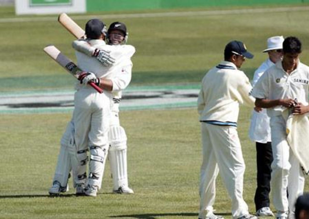 New Zealand batsmen Lou Vincent (left) and Mark Richardson hug to celebrate New Zealand winning the match, beating India by 10 wickets. Indian captain Sourav Ganguly, Australian umpire Daryl Harper and bowler Ashish Nehra are in the foreground. 1st Test: New Zealand v India at Basin Reserve, Wellington, 12-16 December 2002 (14 December 2002).