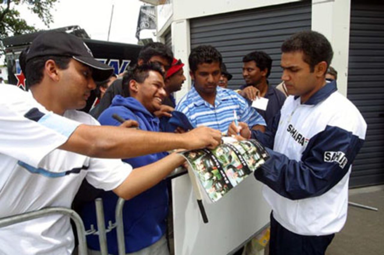 Indian player Virender Sehwag (right) signs autographs for fans as he leaves the ground. 2nd Test: New Zealand v India at Westpac Park, Hamilton, 19-23 December 2002 (19 December 2002).