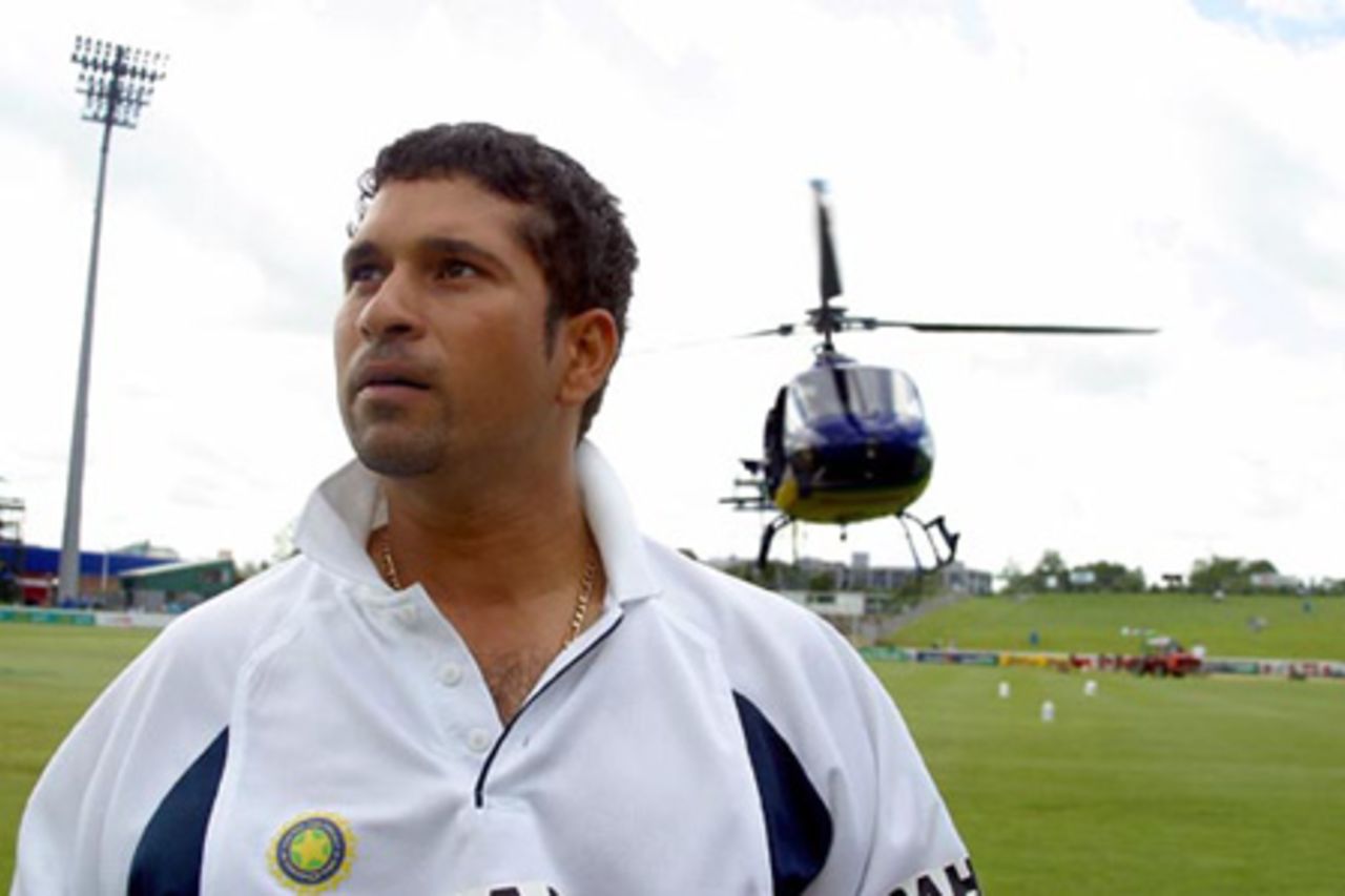 Indian player Sachin Tendulkar inspects the condition of the ground as a helicopter hovers in the background to dry the field. 2nd Test: New Zealand v India at Westpac Park, Hamilton, 19-23 December 2002 (20 December 2002).