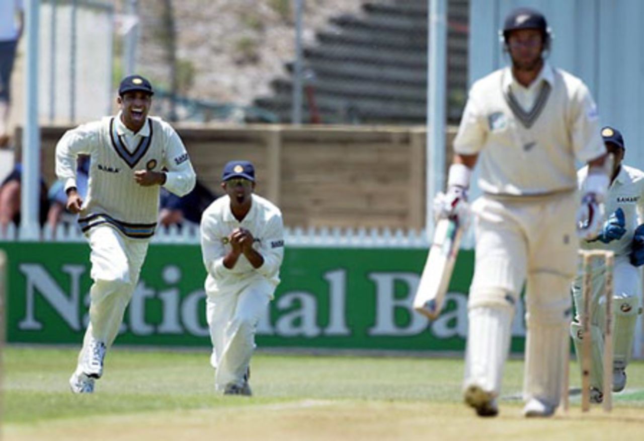 New Zealand batsman Craig McMillan (right) walks off the field as Indian fielders VVS Laxman (left) and Rahul Dravid celebrate his dismissal, caught by Dravid at first slip off the bowling of Ashish Nehra for four. 2nd Test: New Zealand v India at Westpac Park, Hamilton, 19-23 December 2002 (21 December 2002).