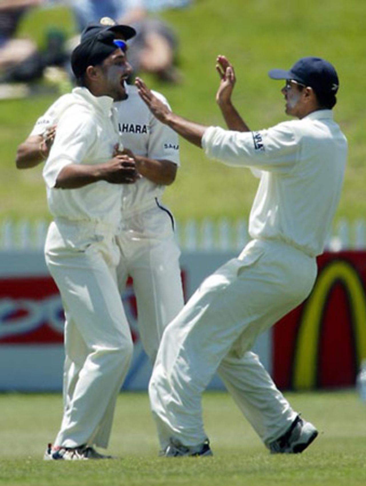 Indian fielder Harbhajan Singh (left) and team-mate Rahul Dravid celebrate the dismissal of New Zealand batsman Nathan Astle, caught by Harbhajan at backward point off the bowling of Nehra for 0 in his first innings. 2nd Test: New Zealand v India at Westpac Park, Hamilton, 19-23 December 2002 (21 December 2002).