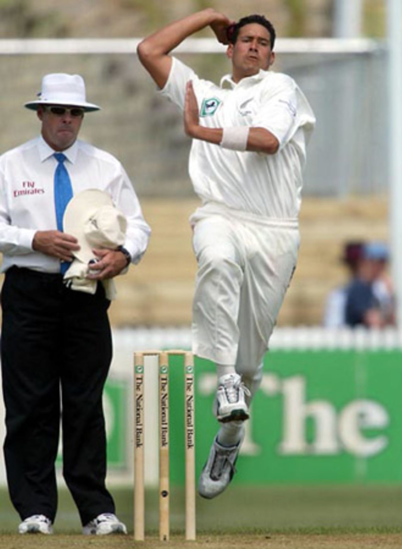 New Zealand bowler Daryl Tuffey delivers a ball during his spell of 4-41 from 16 overs in the second innings as umpire Daryl Harper looks on. 2nd Test: New Zealand v India at Westpac Park, Hamilton, 19-23 December 2002 (21 December 2002).