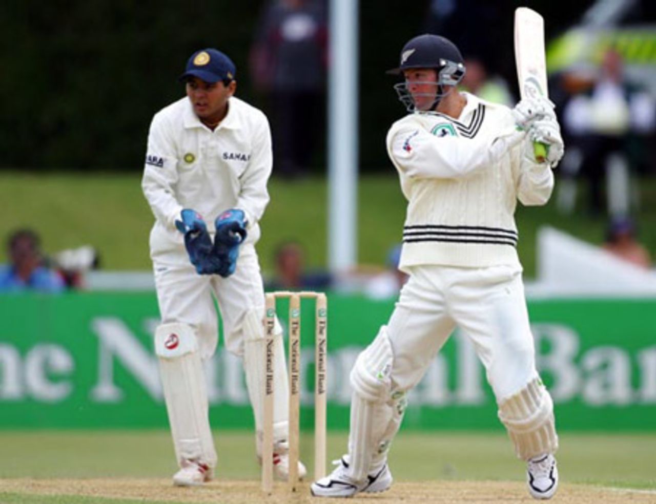 New Zealand batsman Nathan Astle cuts a delivery from Indian bowler Harbhajan Singh during his second innings of 14 as wicket-keeper Parthiv Patel looks on. 2nd Test: New Zealand v India at Westpac Park, Hamilton, 19-23 December 2002 (22 December 2002).