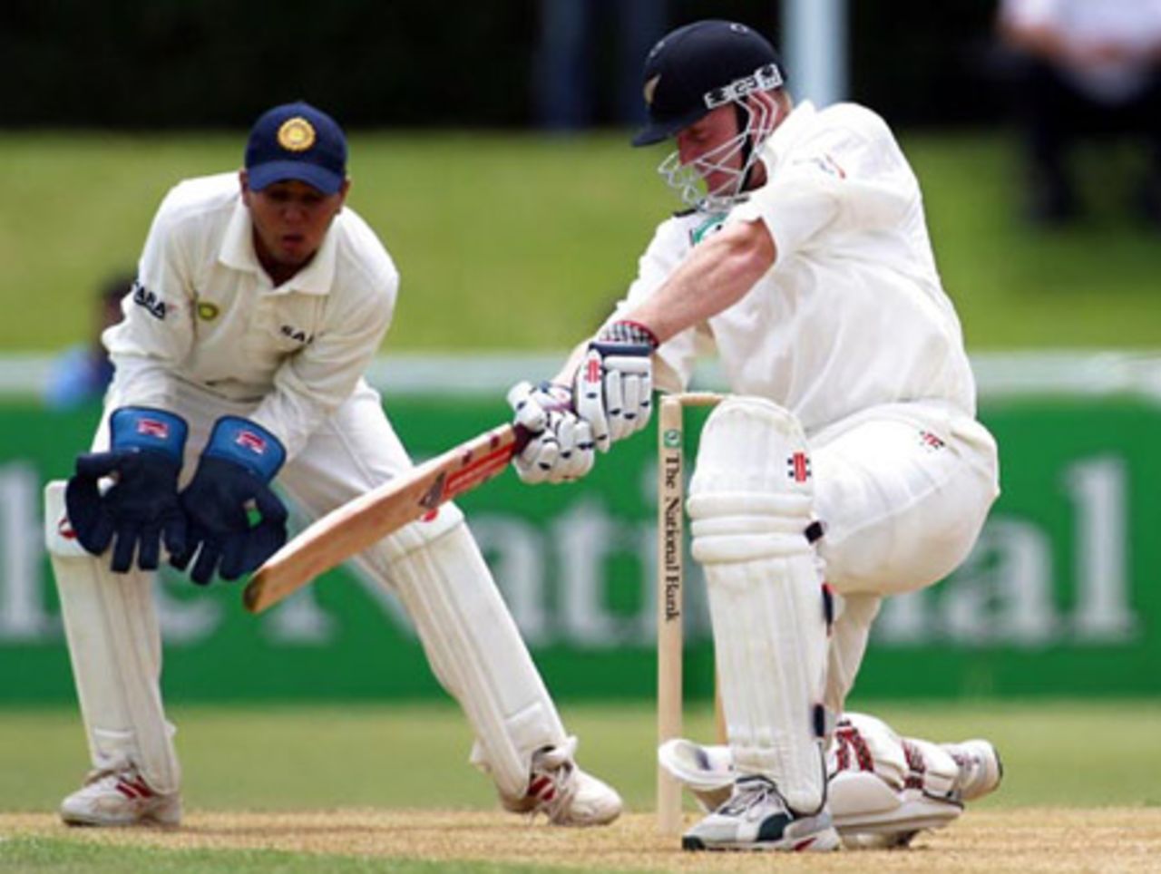 New Zealand batsman Scott Styris square drives a delivery from Indian bowler Harbhajan Singh during his second innings of 17 as wicket-keeper Parthiv Patel looks on. 2nd Test: New Zealand v India at Westpac Park, Hamilton, 19-23 December 2002 (22 December 2002).