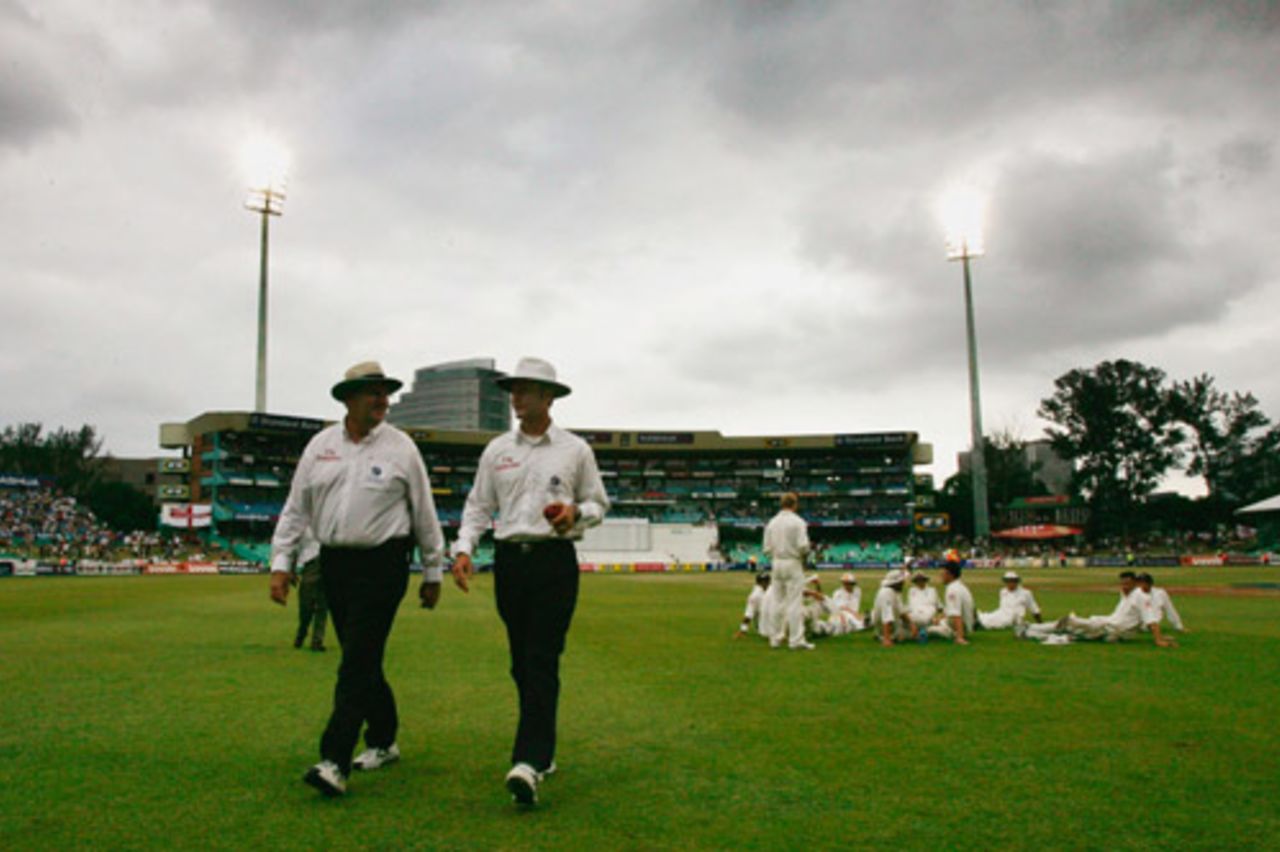 Darrell Hair and Simon Taufel leave the field while England wait for the light to improve, South Africa v England, 2nd Test, Durban, 5th day, December 30 2004